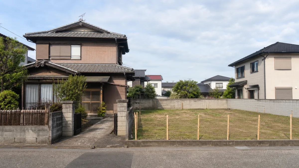 古い実家が残る土地と更地になった住宅用地を並べて比較する景観
